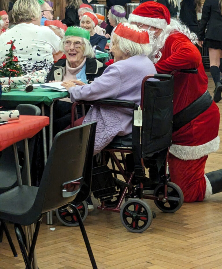 Santa entertains the guests at Oxted School's lunch for senior citizens