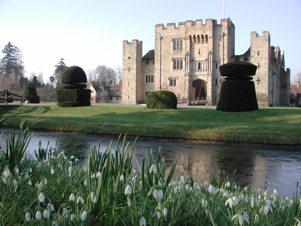 Hever Castle with the moat and a bank of snowdrops in front of it
