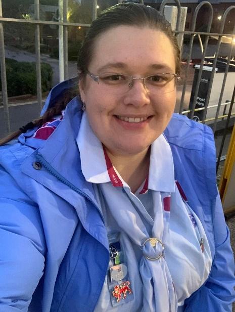 A Girlguiding leader wearing uniform and glasses